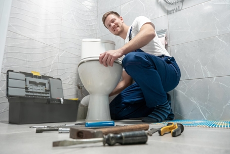 plumber fixing toilet