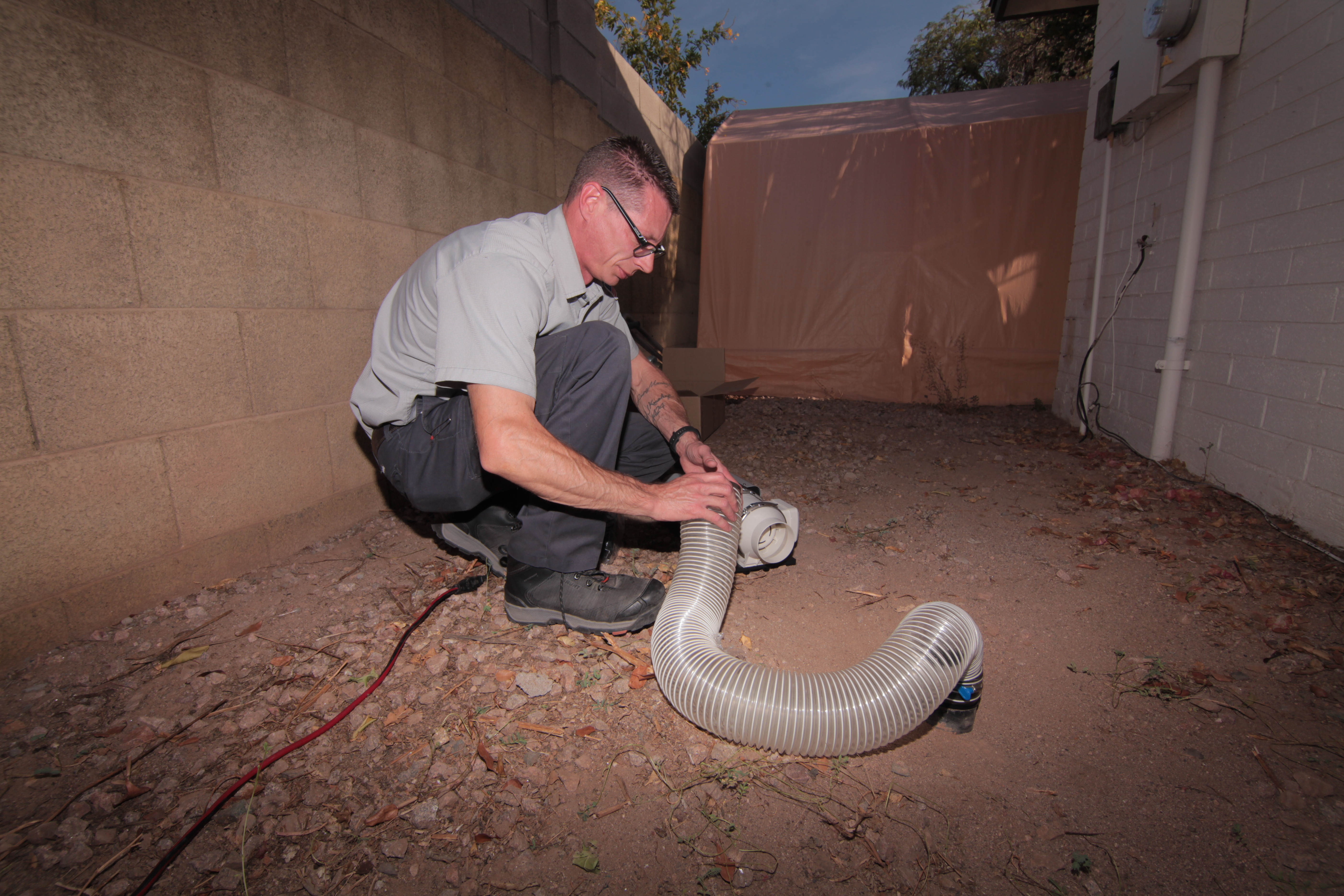 EZ Flow Plumbing technician connecting the FogTrace smoke test hose and blower unit at a Gilbert, AZ home