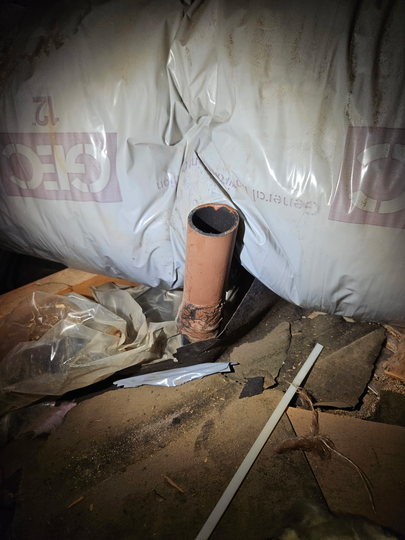 Kitchen plumbing vent pipe found terminating in the attic insulation instead of being extended through the roof, the source of the sewer gas odor